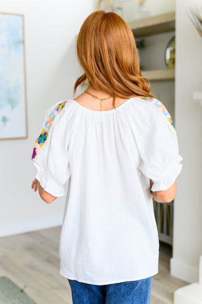 Crafted from lightweight cotton gauze, this peasant blouse features a crochet granny square shoulder accent and a self-tie keyhole neckline closure for added flair. Perfect for a casual day out or a festival, this blouse will keep you comfortable and stylish.