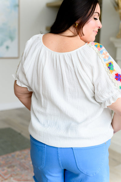 Crafted from lightweight cotton gauze, this peasant blouse features a crochet granny square shoulder accent and a self-tie keyhole neckline closure for added flair. Perfect for a casual day out or a festival, this blouse will keep you comfortable and stylish.