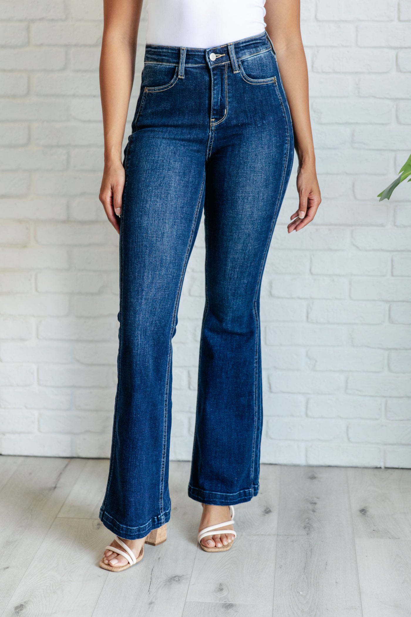 These high waisted, non-distressed jeans feature a dark wash and unique offset side seam detail for a flattering fit