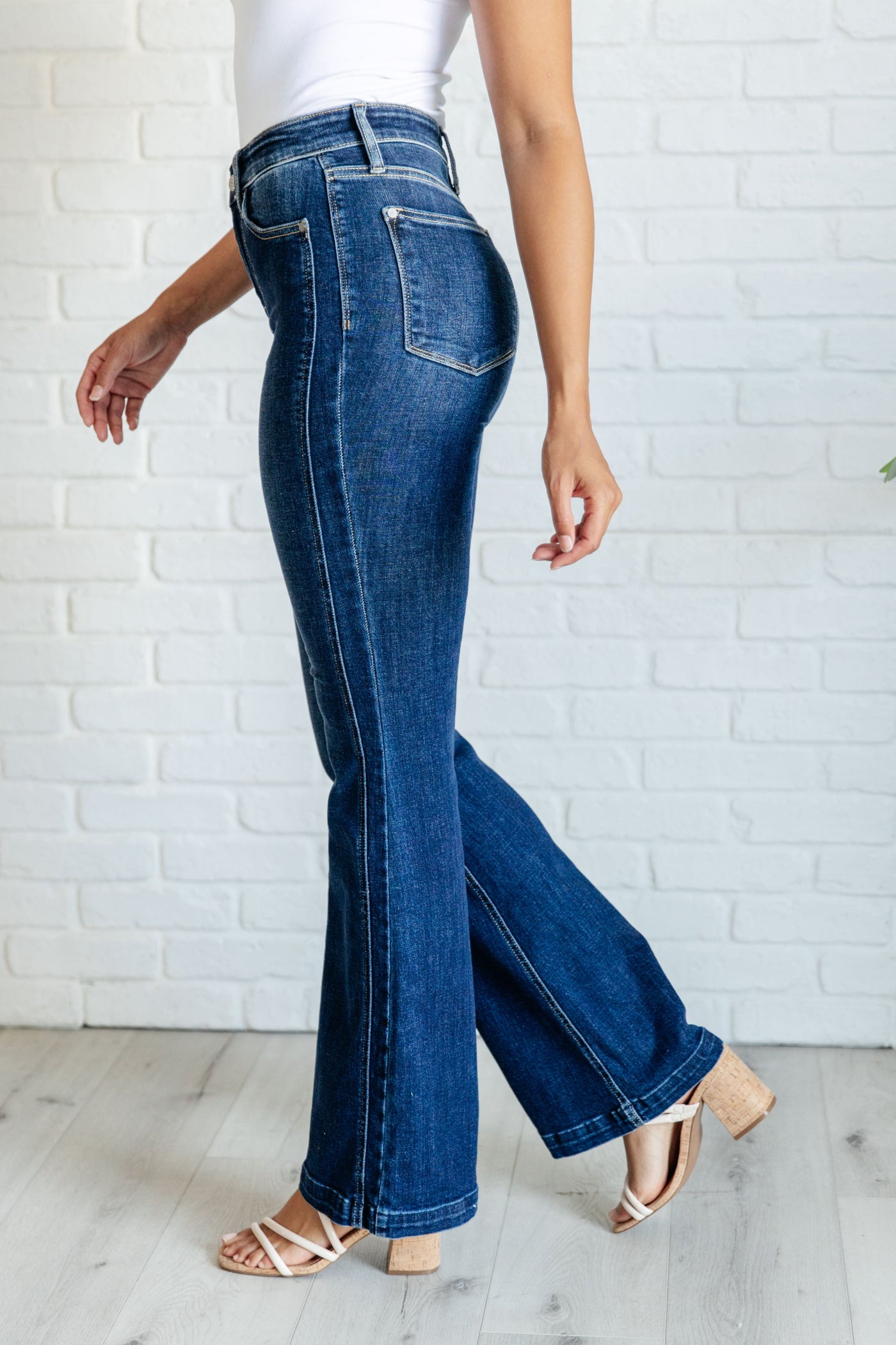 These high waisted, non-distressed jeans feature a dark wash and unique offset side seam detail for a flattering fit