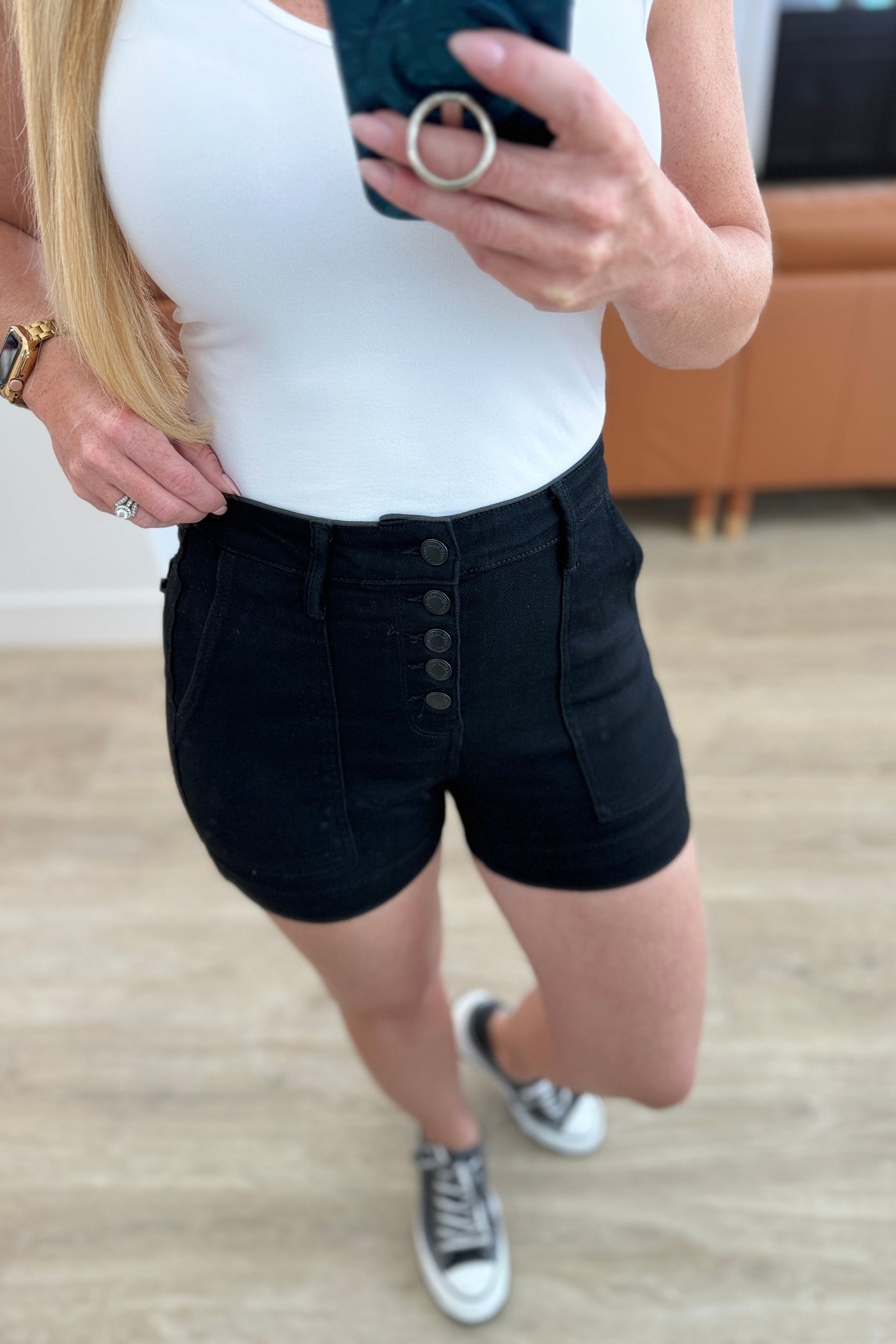 These high-waisted shorts feature a coordinating button fly and a saturated black color for a sleek and stylish look. With trouser pockets and a non-distressed design, these shorts are both functional and fashionable