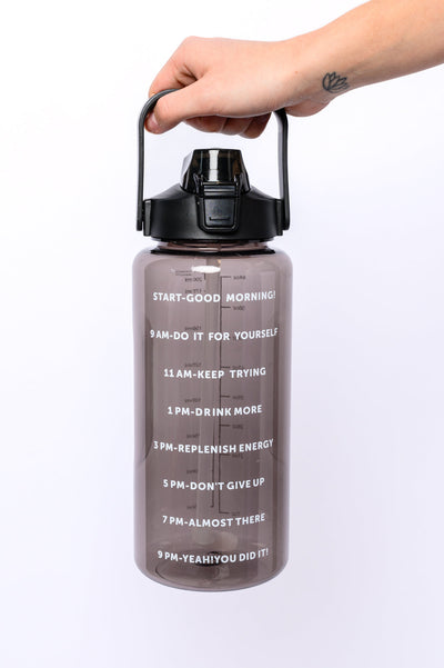Quench your thirst with the Elevated Water Tracking Bottle in Black! This enchanting 64-ounce bottle is adorned with adorable inspirational sayings, urging you to sip your way to hydration bliss