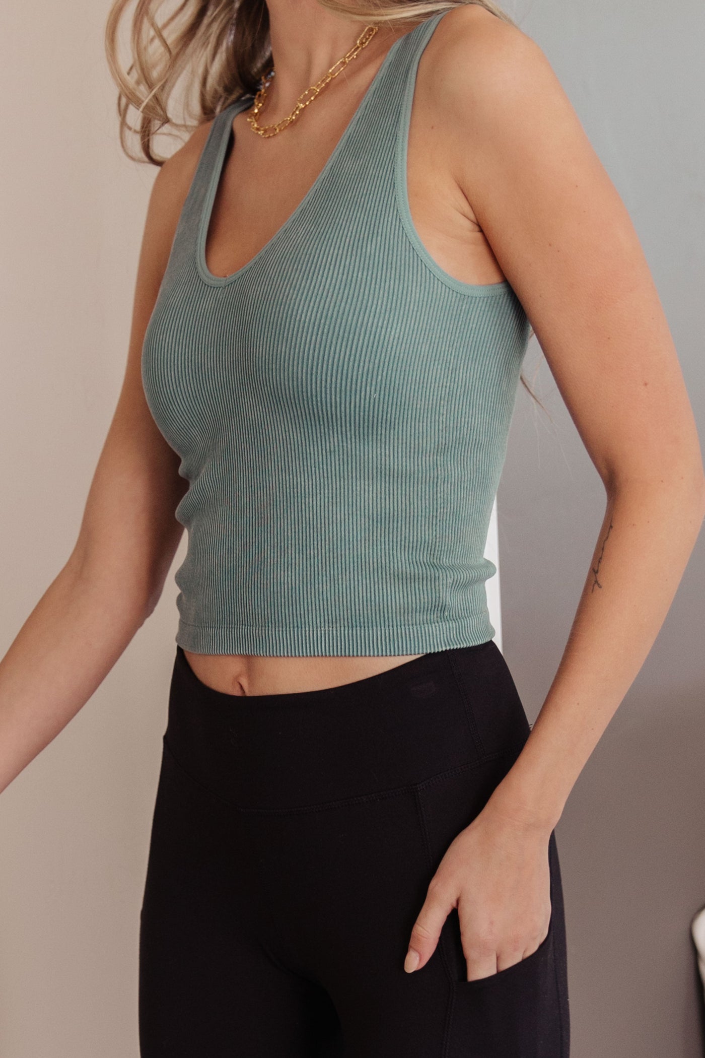 Crafted from ribbed fabric with a seamless finish, it offers a flattering, cropped fit that can be customized with your choice of v-neck or scoop neck.