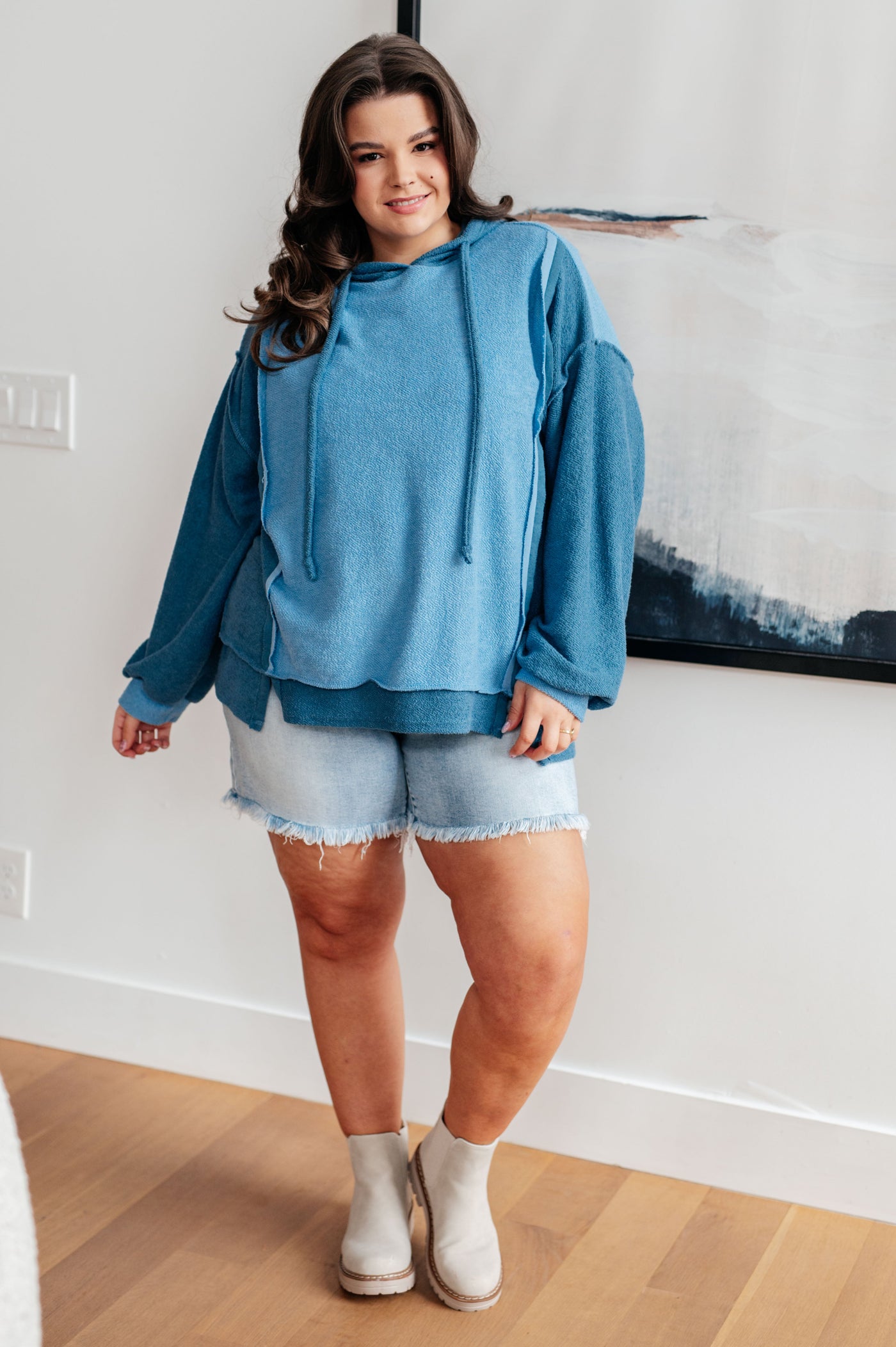 With a functional drawstring and dropped shoulder design, it's the perfect mix of style and functionality. Exposed seams and a stepped hem add a unique touch.