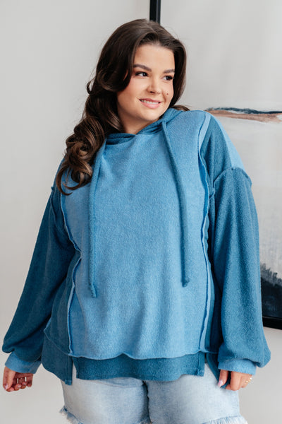 With a functional drawstring and dropped shoulder design, it's the perfect mix of style and functionality. Exposed seams and a stepped hem add a unique touch.