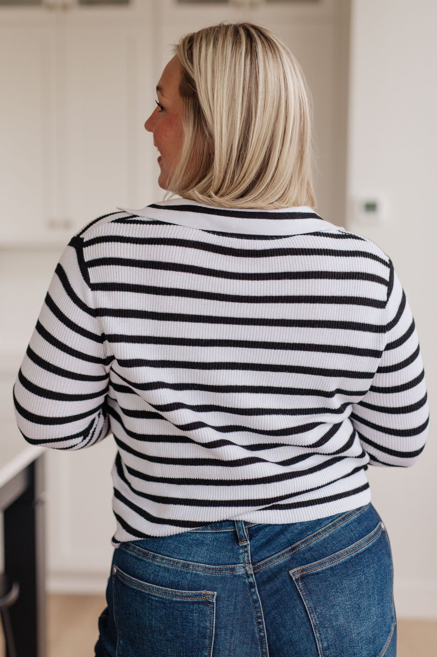 This lightweight sweater knit features a classic stripe print, with a collared v-neckline to complete the look