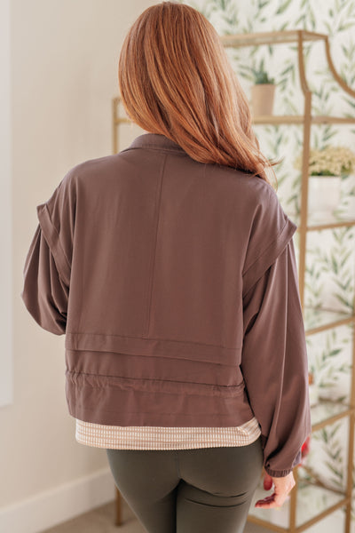 Crafted of a textured woven athletic material, this zip-up jacket features an elastic drawstring waistband, patch pockets, and a sleek, sporty silhouette.