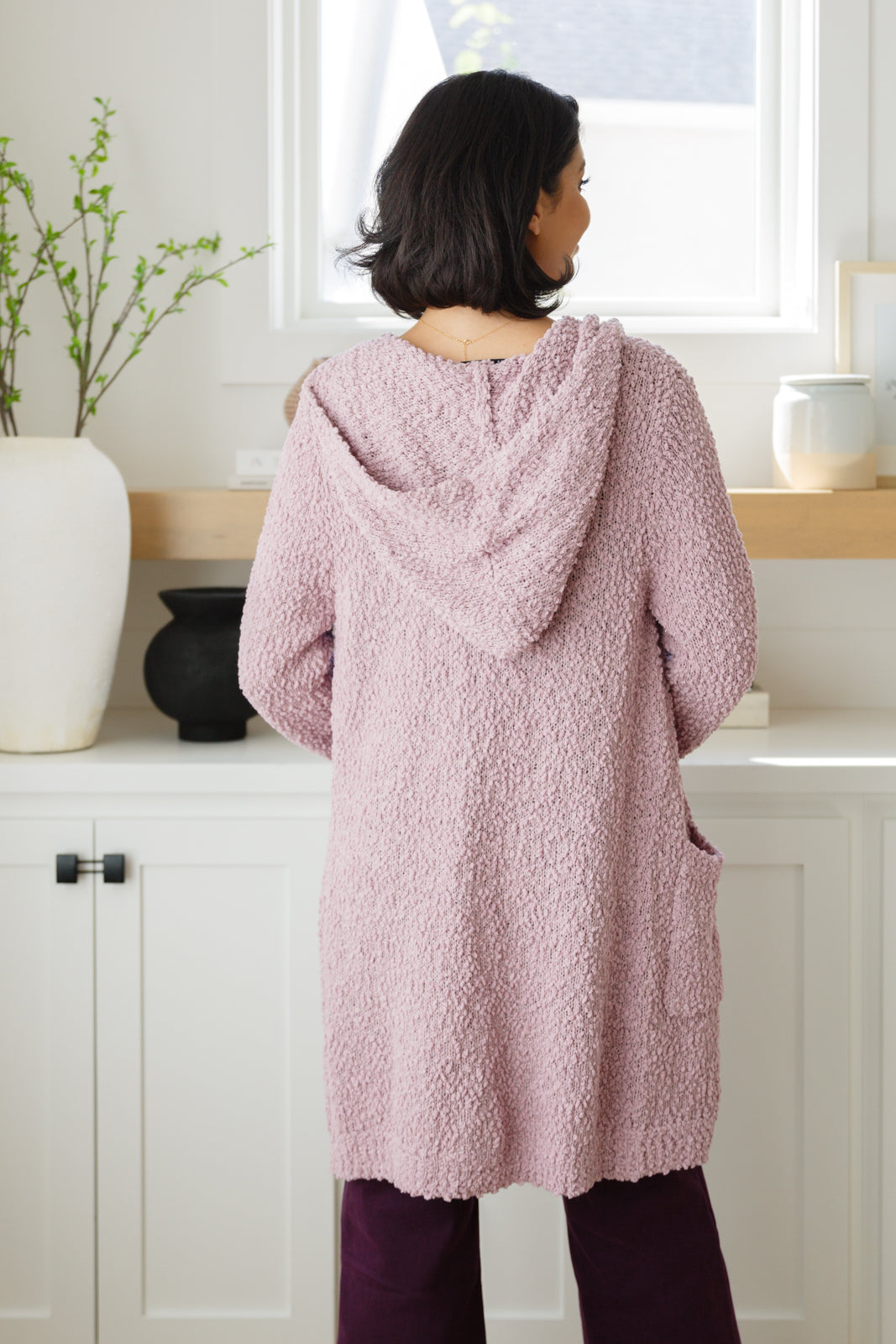 Crafted from a soft and luxurious boucle knit, this cardigan features a hooded design, button closure, front pockets, and an oversized fit for a look that's both chic and cozy