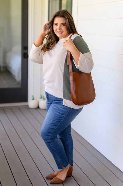 Crafted from faux leather, its scoop shaped tote design is paired with a sleek, matching zippered pocket with wristlet, and adjustable strap for maximum comfort. Upgrade your style toda