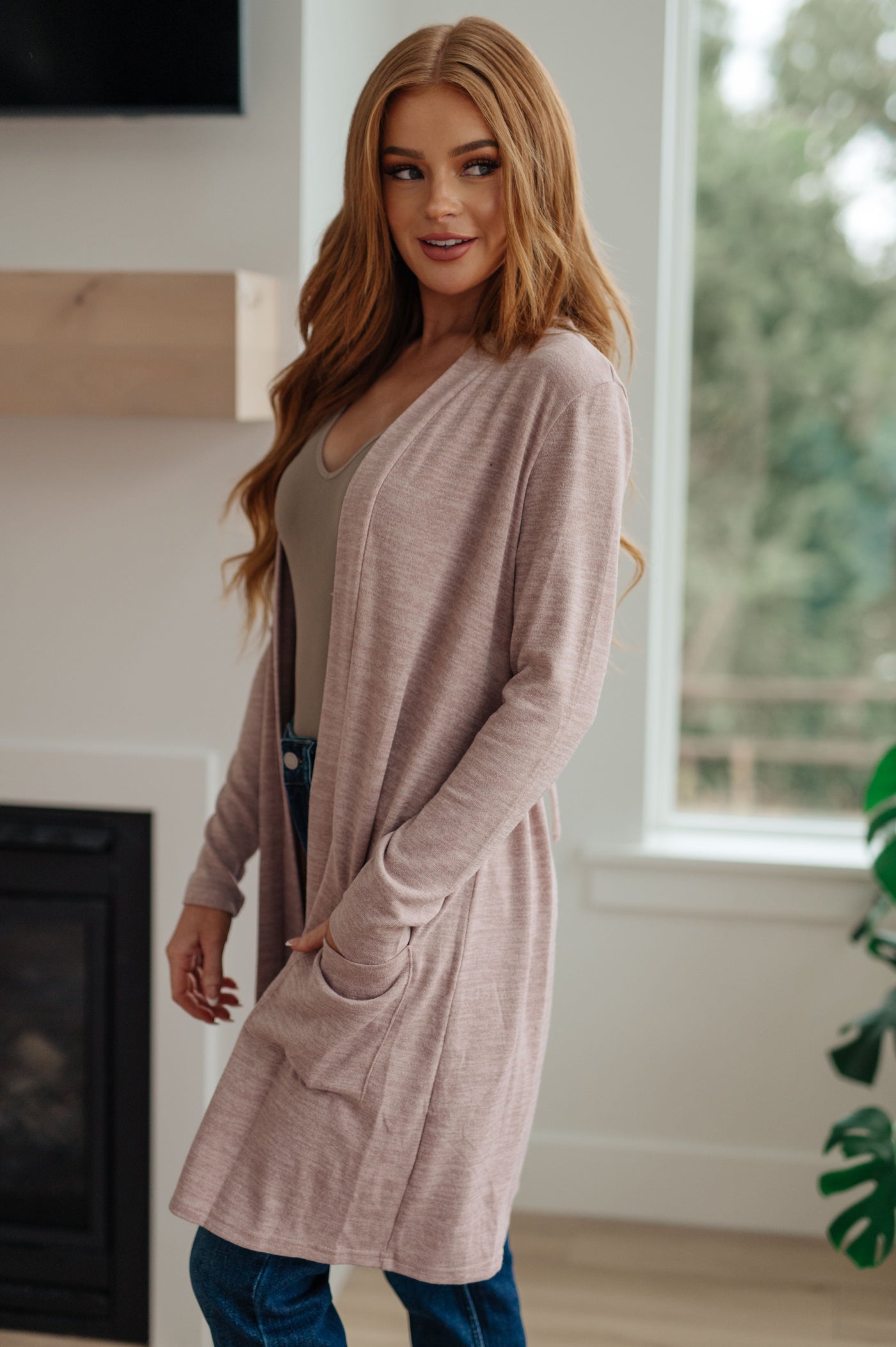 Features a sweater knit construction and an open front, with a drawstring in the back to cinch the waist for a more flattering shape. Perfect for cool days and evenings.