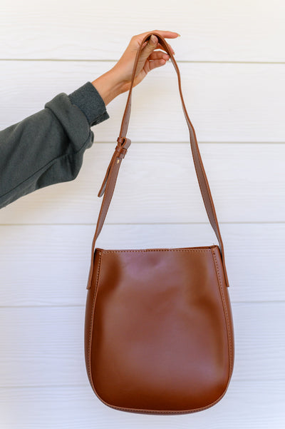 Crafted from faux leather, its scoop shaped tote design is paired with a sleek, matching zippered pocket with wristlet, and adjustable strap for maximum comfort. Upgrade your style toda