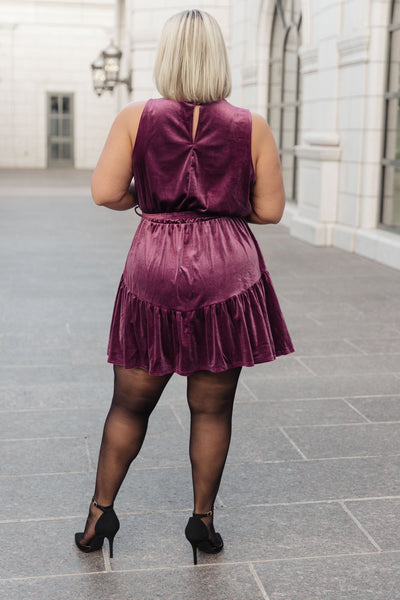 This luxurious velvet dress has a flattering mock neckline, sleeveless design, cased elastic waistband, and comes with a removable self-tie belt and ruffled hem for a chic, sophisticated look